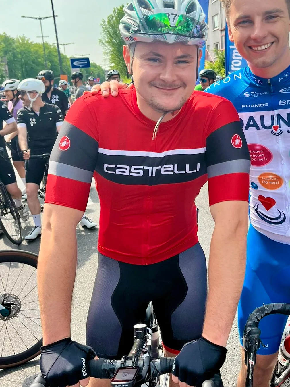 Lennart Böhm at the start line of a road cycling race, wearing a helmet and team jersey.